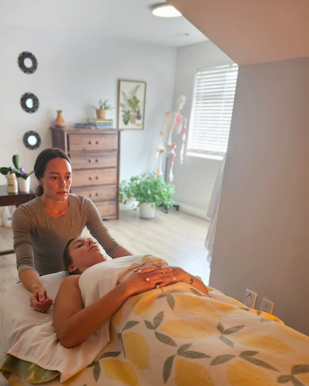 A practitioner treating a client's neck as she rests face up on the table