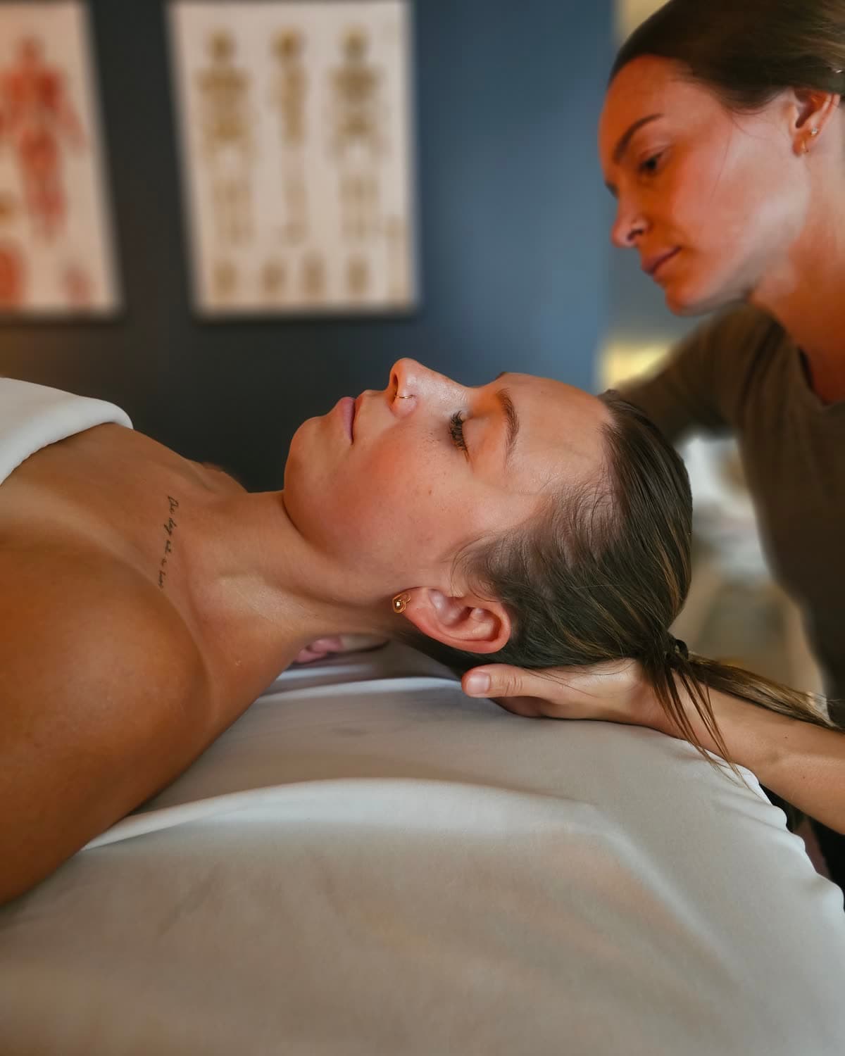 A practitioner gently cradling a client's head and neck during a hands-on session at Back in Health